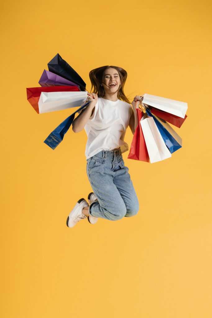portrait-young-female-with-shopping-bags-jumping