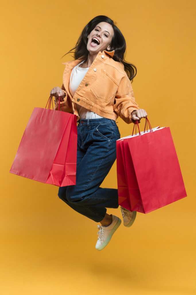 woman-posing-jumping-while-holding-shopping-bags